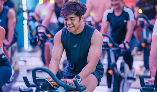 رجل يركب دراجة داخلية بتركيز في صف سبرينت في جيمنيشن ضمن مجموعة نشيطة.